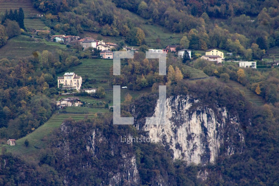 homes on a green slope on a mountainside 