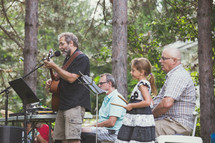 a band spanning generation playing music outdoors 