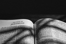 Bible opened to Jeremiah with a shadow cast on it