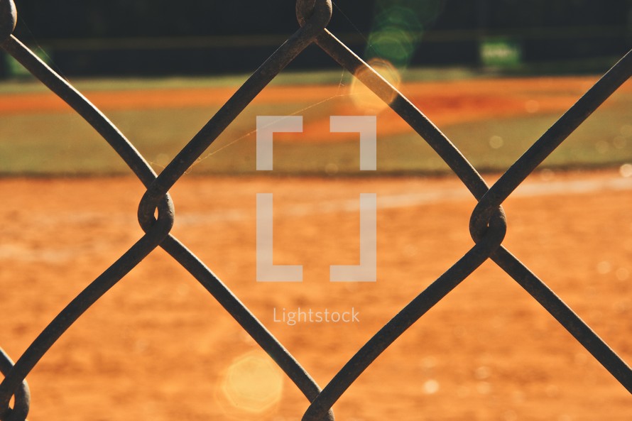 baseball field through a chain linked fence