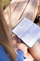 a woman sitting reading a Bible 