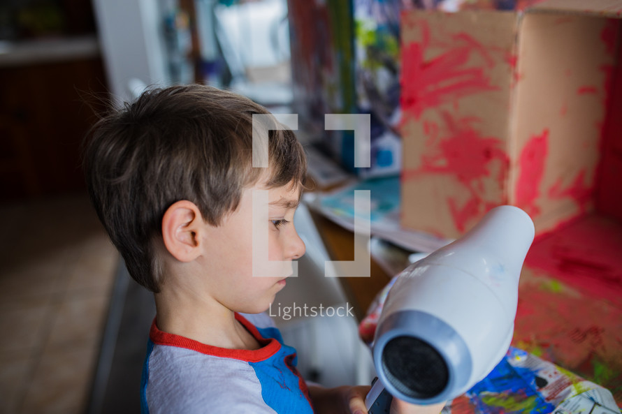 children painting a cardboard box 