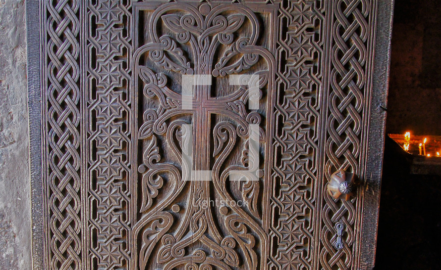 Ornate door open to candlelit room.