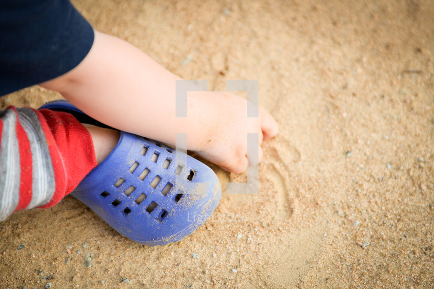 toddler boy playing in sand 