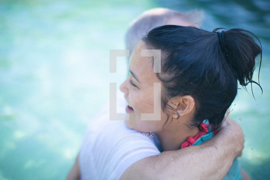 pastor hugging a woman after her baptism 