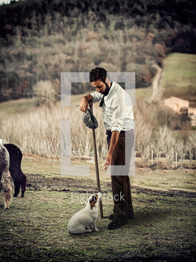 Man with small dog on rural farm land