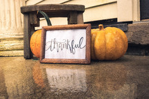 thankful sign and pumpkins on a floor 