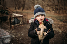 a little boy holding a pet chicken 