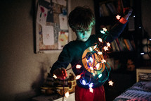 child holding a strand of Christmas lights 
