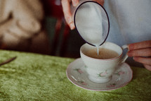pouring cream in tea 