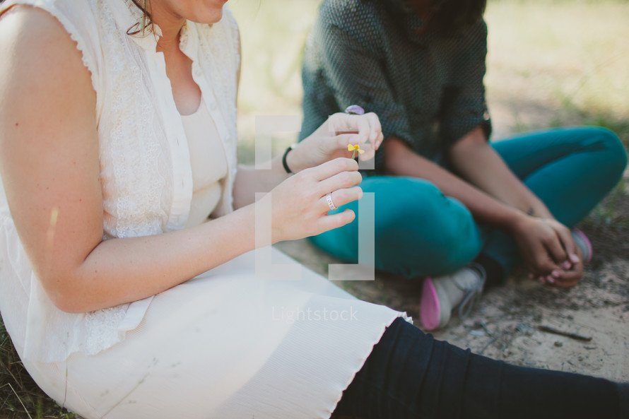 Woman sitting and talking with teen outdoors