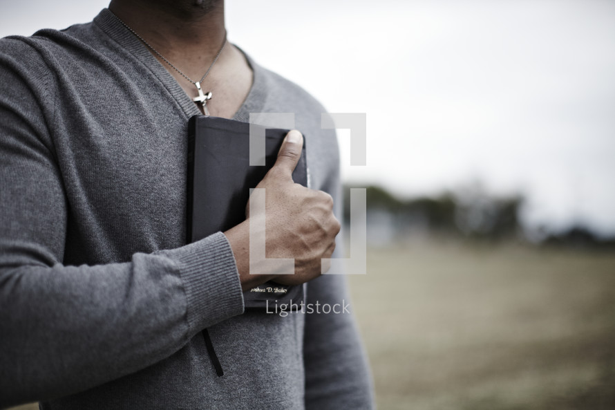 A man holding a bible over his heart