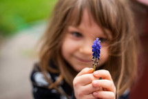 little girl with a purple flower 