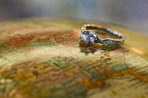 engagement ring on a globe