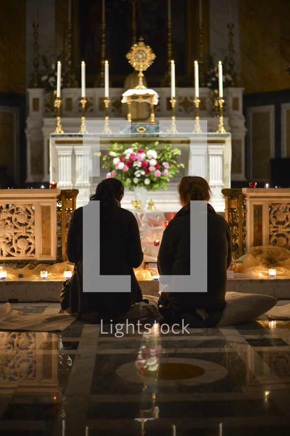 kneeling in prayer to God in front of an altar