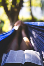 A woman in a hammock reading a Bible.