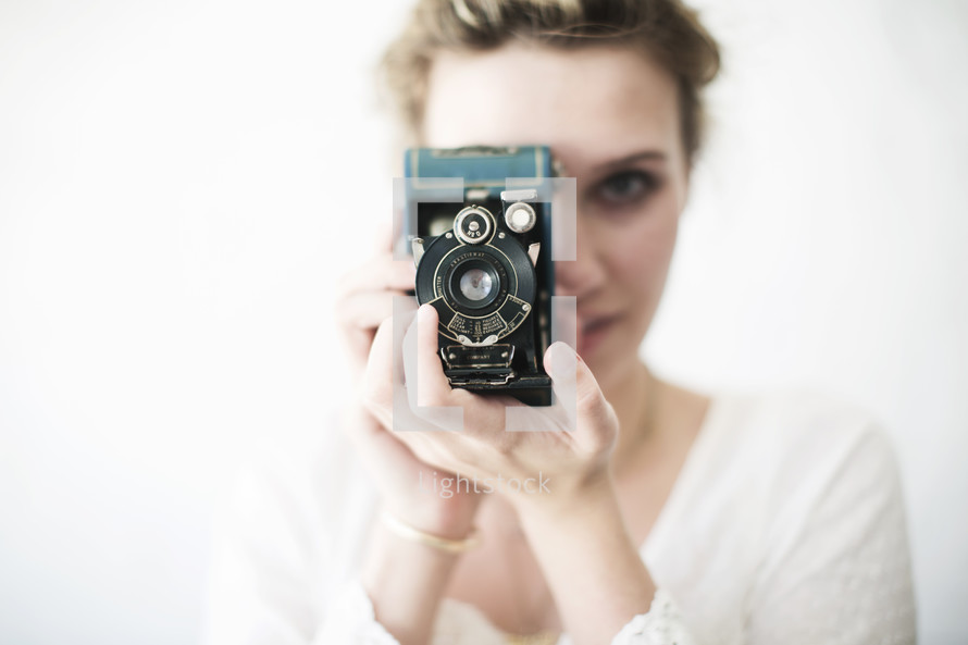 Woman looking through a vintage camera.