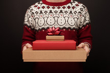 a man holding a stack of Christmas gift boxes 