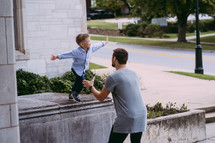 a little boy jumping into his father's arms 