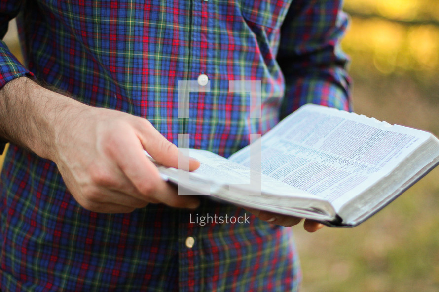 man standing holding a Bible