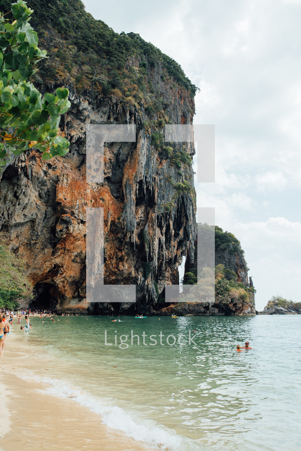 people swimming in the ocean and sea cliffs 