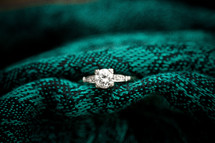 Diamond ring in green adn black blanket.