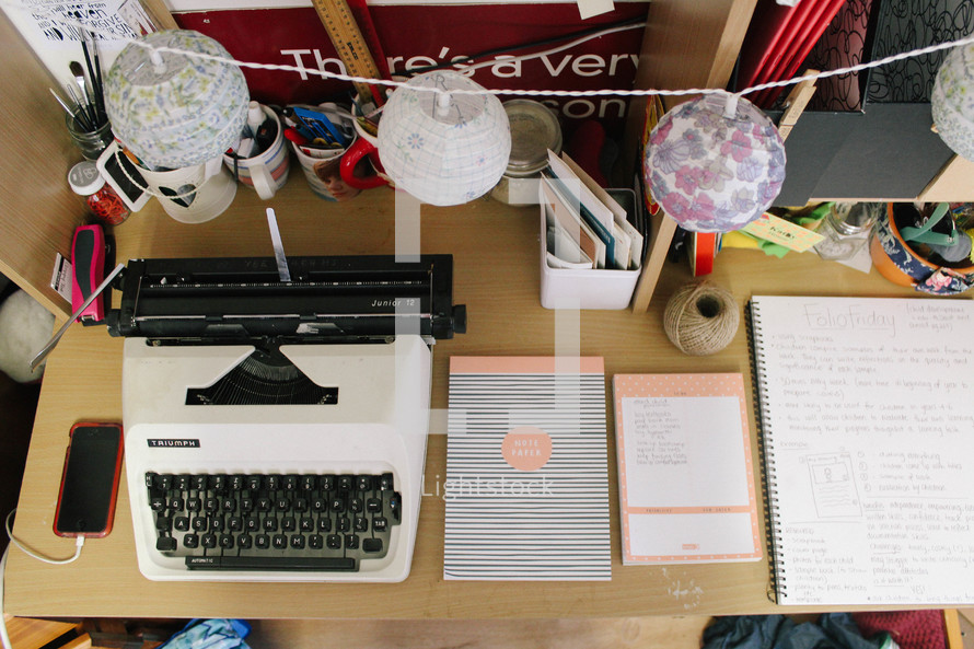 a vintage typewriter and notepads on a desk 