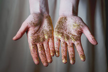 a woman with gold glitter on her hands 