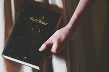 a woman with gold glitter on her hands holding a Bible 
