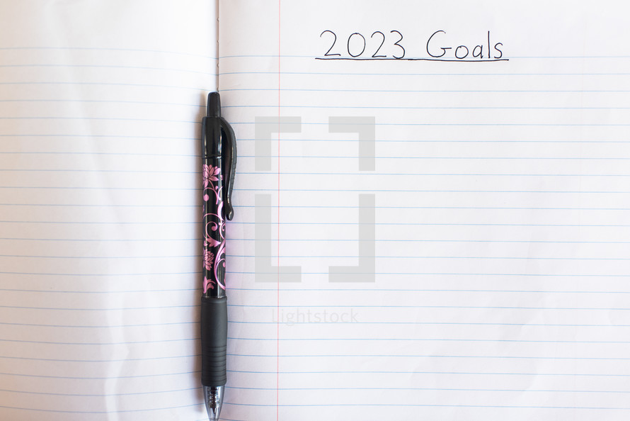 Blank notebook paper with 2023 Goals written on it and pen