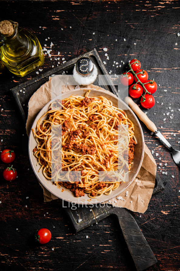 Homemade spaghetti bolognese in a plate on the table. Against a dark background. High quality photo