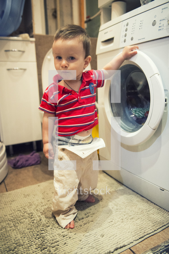 toddler boy in the laundry room 