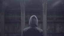 man in a hoodie with his back turned to the camera 