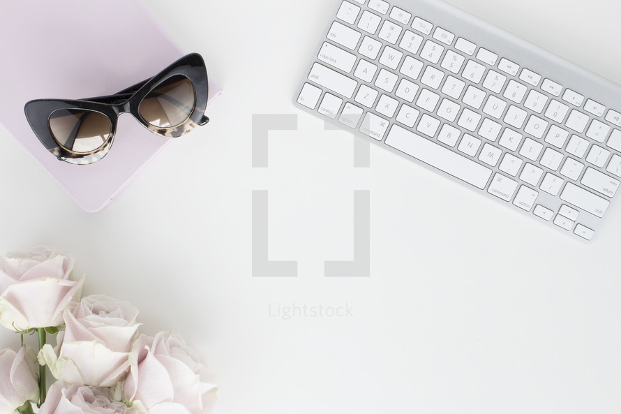roses, notebook, sunglasses, and computer keyboard 