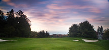 The sun sets over a golf course near Port Carling, ON in the Muskoka's. A beautiful purple hue constants the green grass.