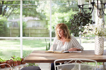a woman reading a Bible on her porch 