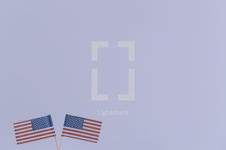 Two American flags against a white background.