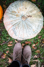 Feet in a pumpkin patch.