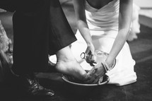 Bride washing a groom's feet.