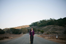 Woman standing in the middle of the road.