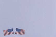 Two American flags against a white background.