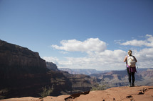woman standing at the edge of a canyon cliff 