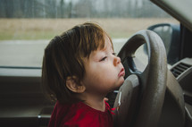 toddler girl at the steering wheel 