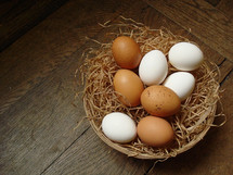 white and brown eggs in a basket