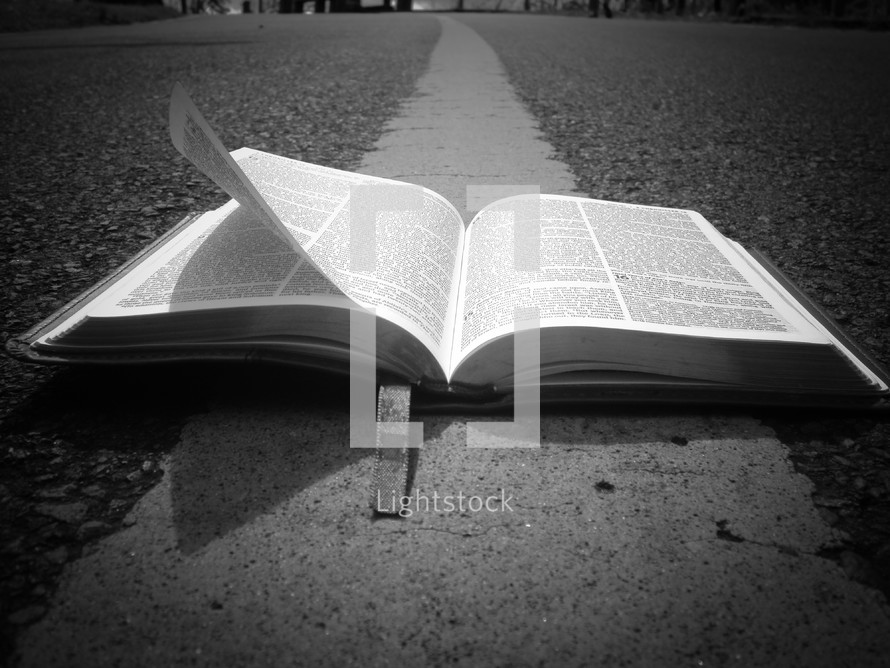 open Bible on the center lines of a road 