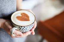 woman holding cup with cinnamon heart 