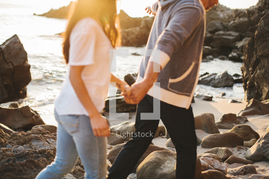 couple walking holding hands on a beach