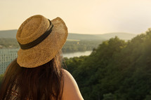 a woman in a hat taking in a view 
