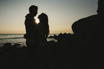 silhouette of a couple hugging on a beach