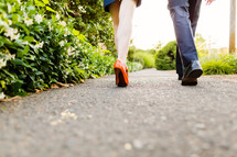 Couple's feet walking on a path.